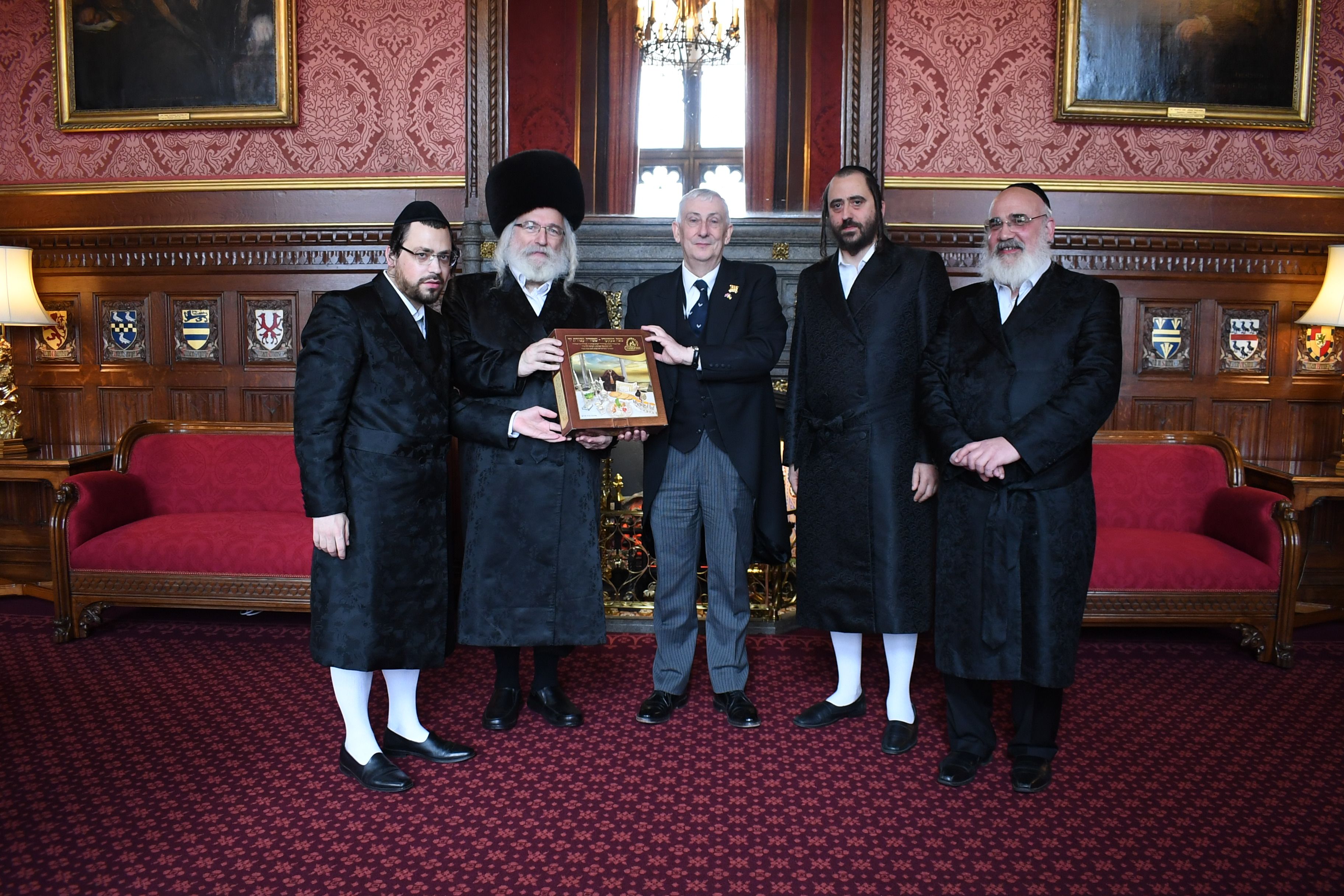 Speaker holding a box of Matzos in photo with Passover delegation