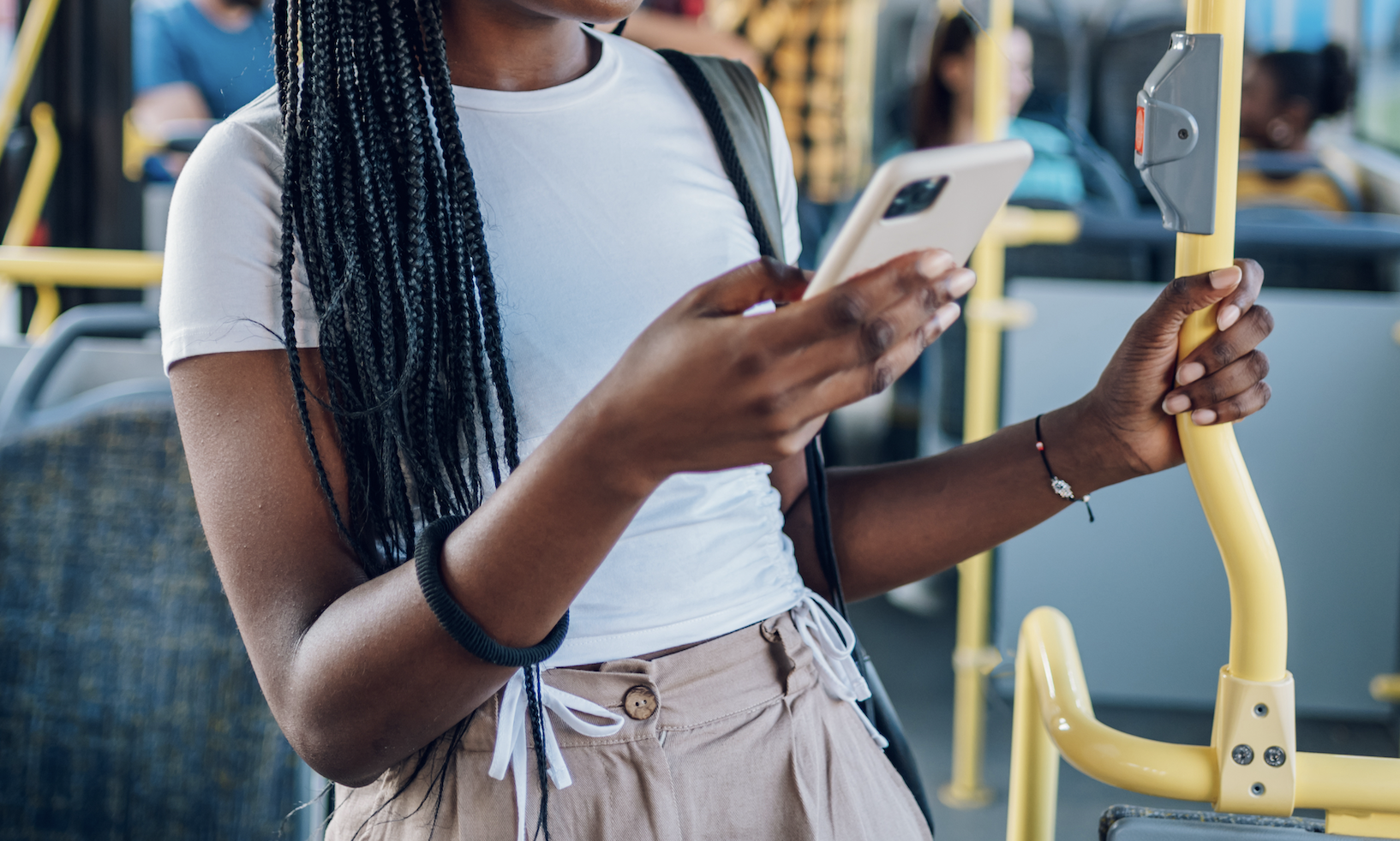 Young woman standing on a bus looking at her phone