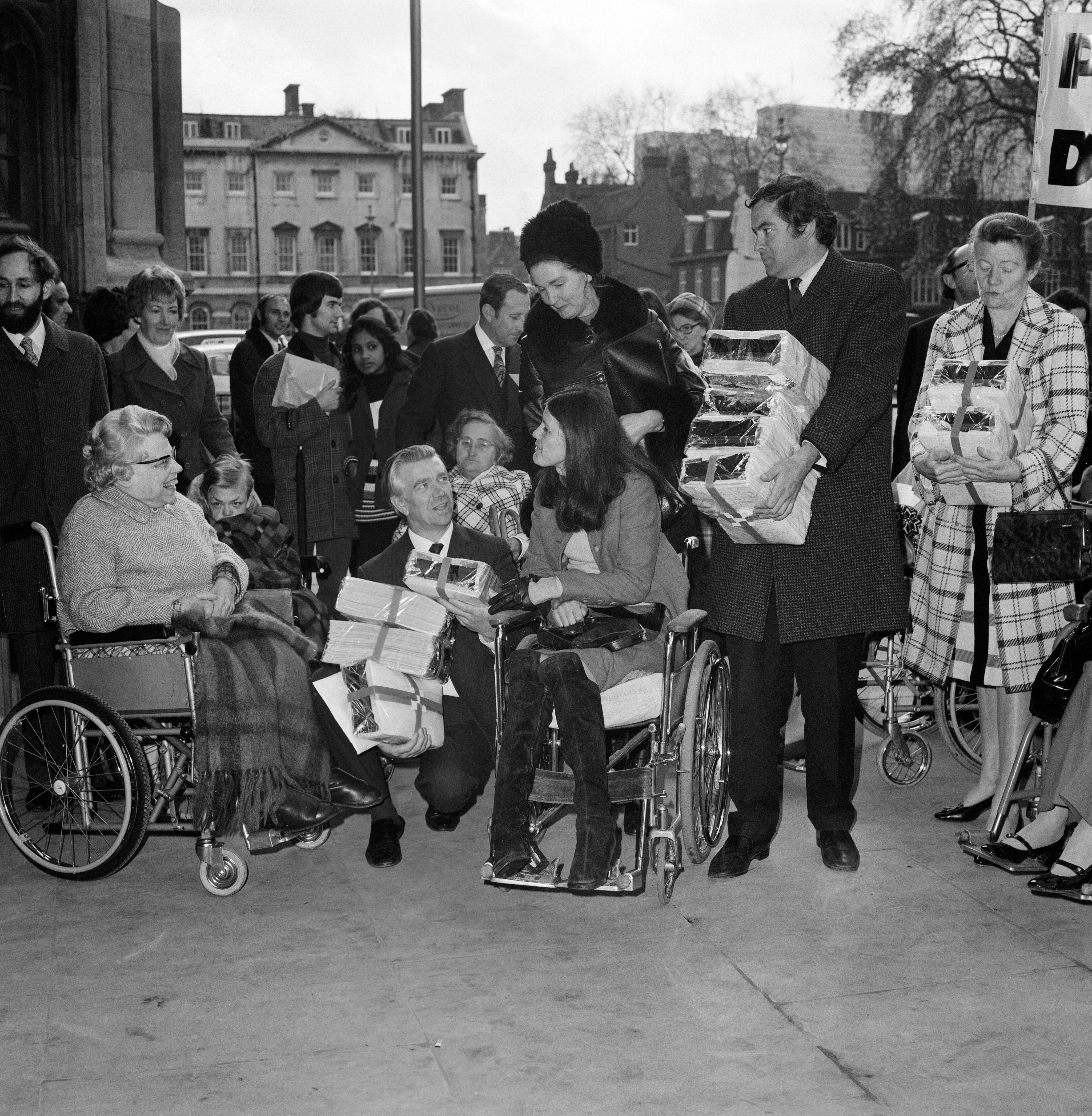 Image of disabled people taking the petition to the House of Commons on the 14th of October 1972. Pictured, Jack Ashley, MP centre, with Rosalie Wilkins (in wheelchair).